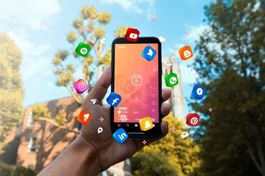 Freelance digital marketer holding a smartphone with various social media icons floating around, representing social media marketing and online engagement.